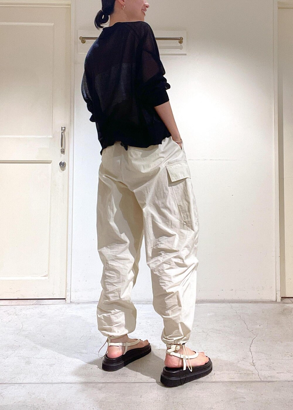 ブラック系のカーディガン/ボレロ、ホワイト系のカーゴパンツ、ホワイト系のサンダルを着用したレディースの夏コーディネートの4枚目の写真