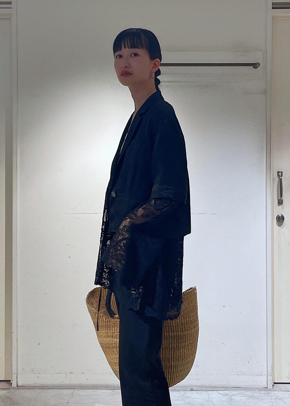 グレー系のデニムパンツ、ブラック系のノーカラージャケット、ブラック系のサンダルを着用したレディースの夏コーディネートの5枚目の写真