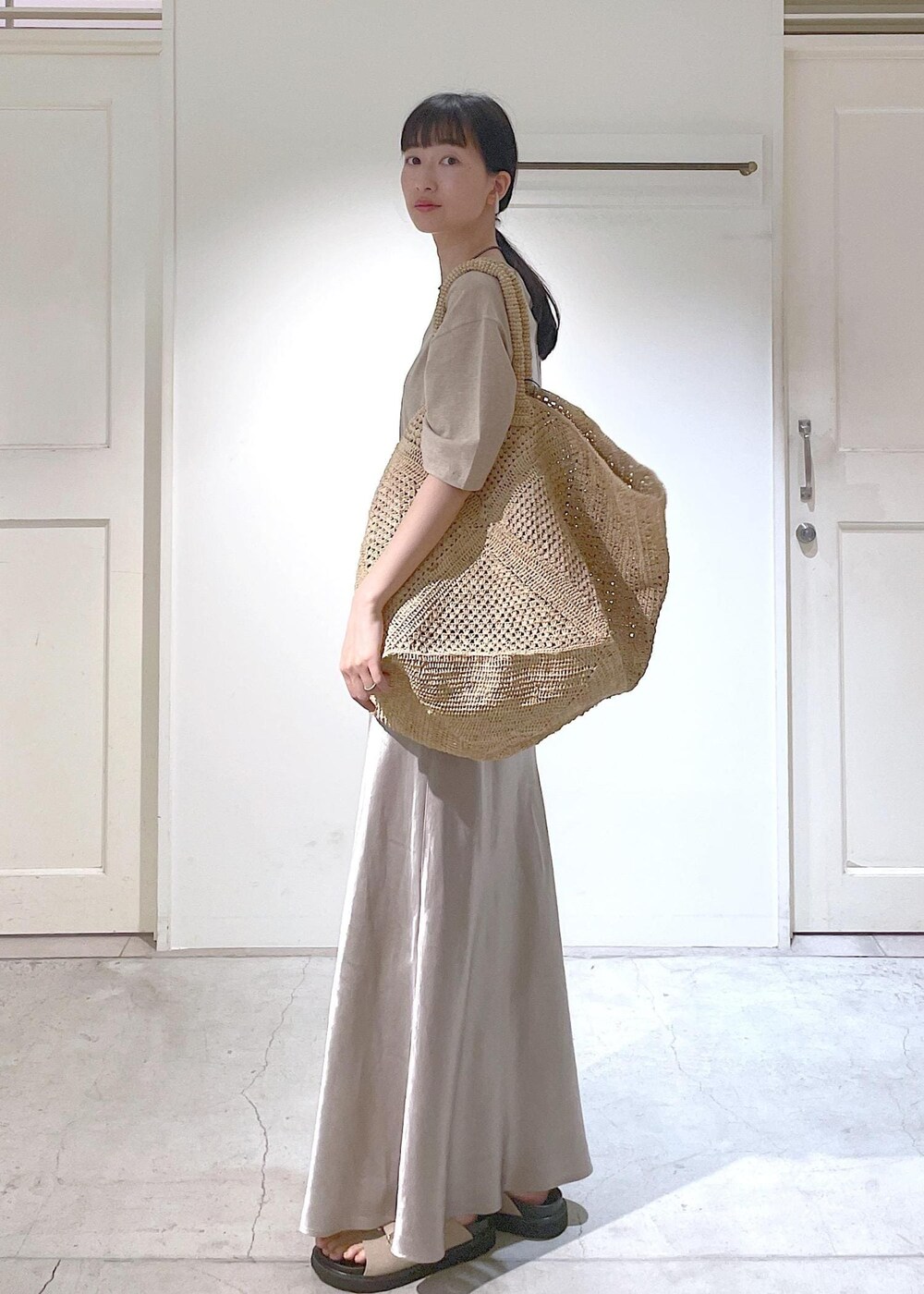 ベージュ系のサンダル、ベージュ系のスカート、ベージュ系のTシャツ/カットソーを着用したレディースの春コーディネートの2枚目の写真