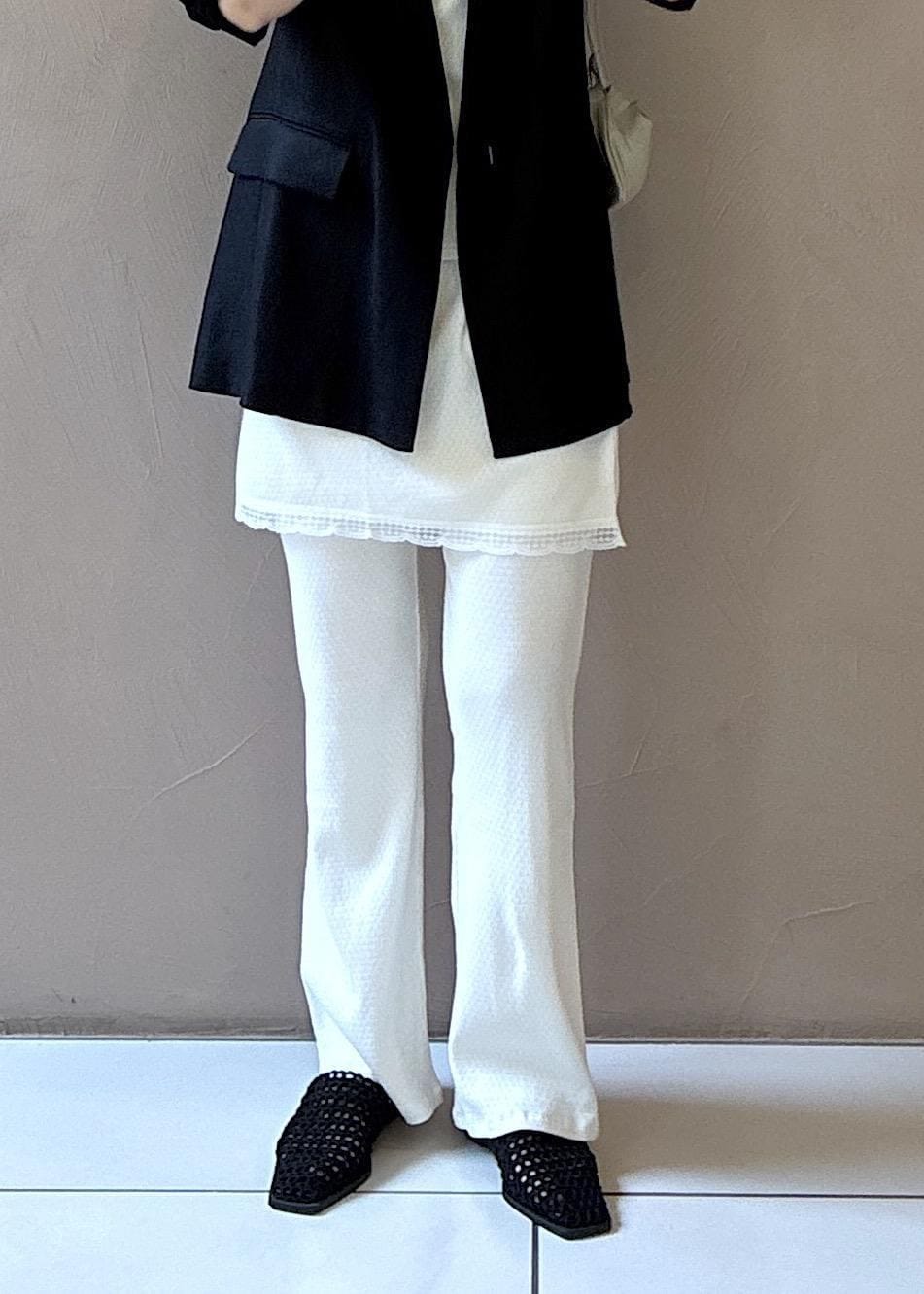 ブラック系のテーラードジャケット、ブラック系のサンダル、ホワイト系のキャミソールを着用したレディースの春コーディネートの5枚目の写真