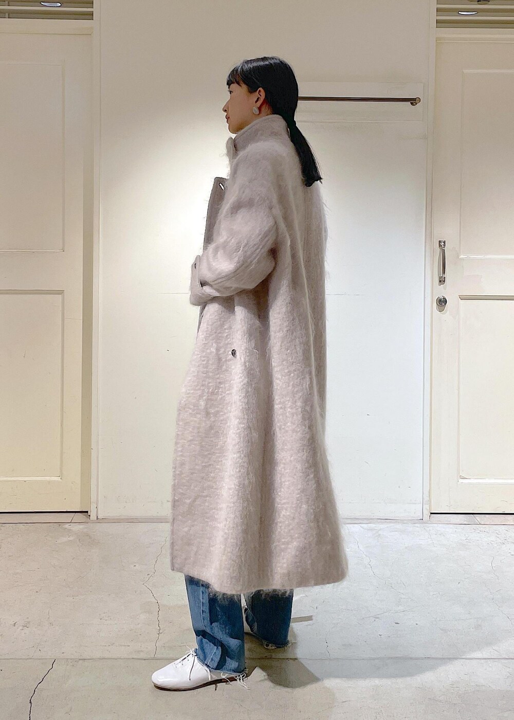 グレー系のその他アウター、ブルー系のデニムパンツ、ホワイト系のその他シューズを着用したレディースの冬コーディネートの6枚目の写真
