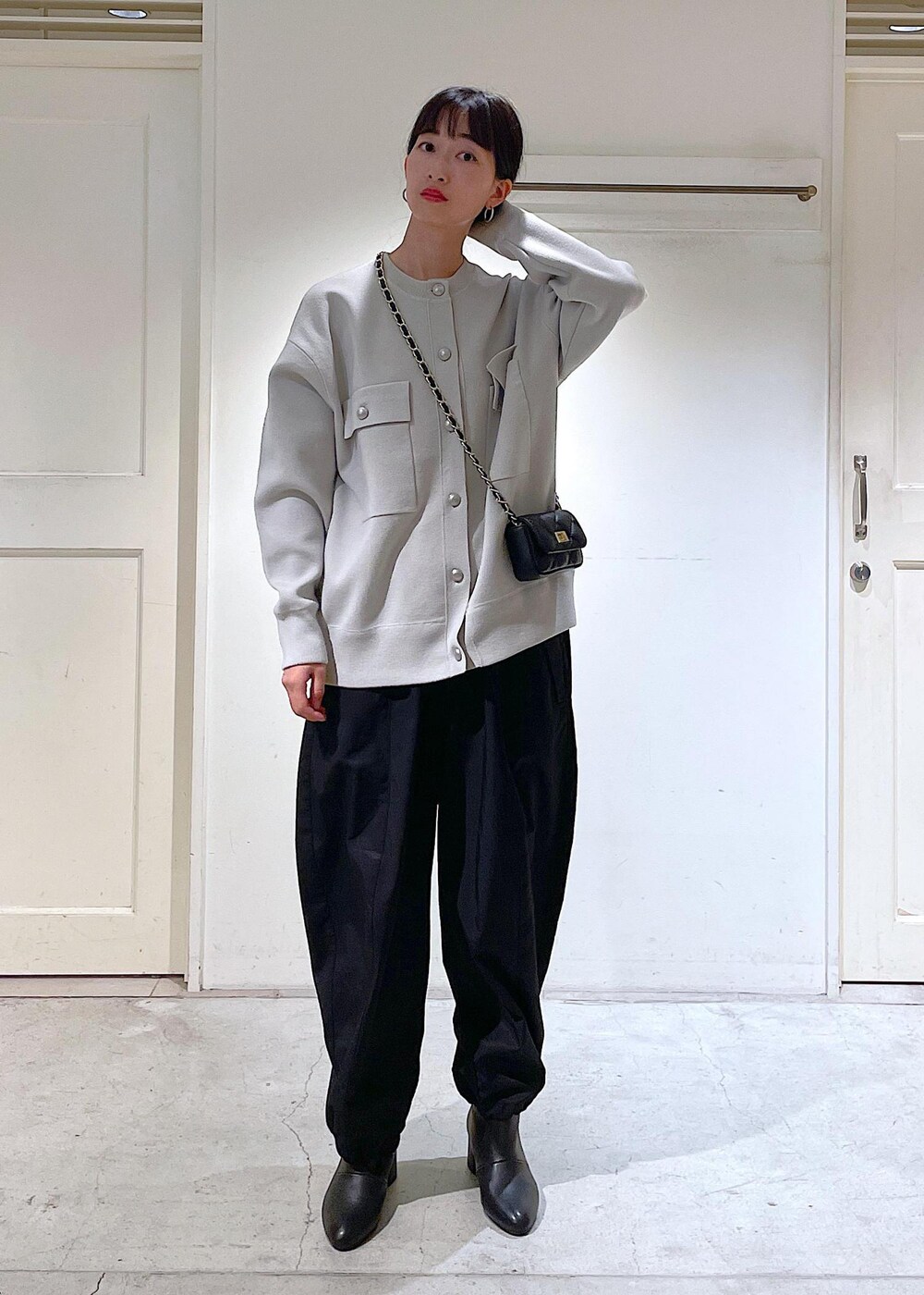 ブラック系のショルダーバッグ、ブラック系のカーゴパンツ、ブラック系のブーツを着用したレディースの秋コーディネートの4枚目の写真