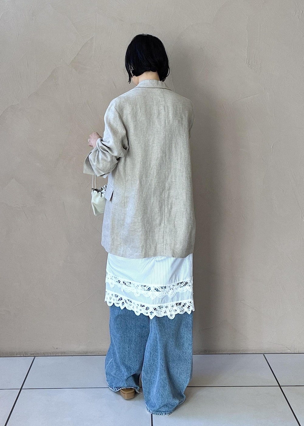 イエロー系のその他シューズ、ベージュ系のテーラードジャケット、ブルー系のデニムパンツを着用したレディースの冬コーディネートの4枚目の写真