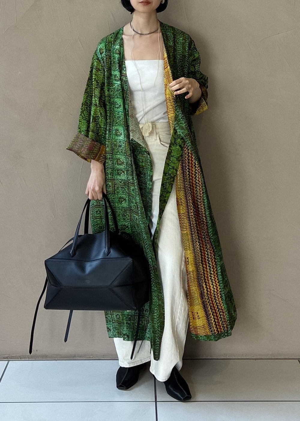 ブラック系のその他シューズ、ブラック系のハンドバッグを着用したレディースの冬コーディネートの3枚目の写真