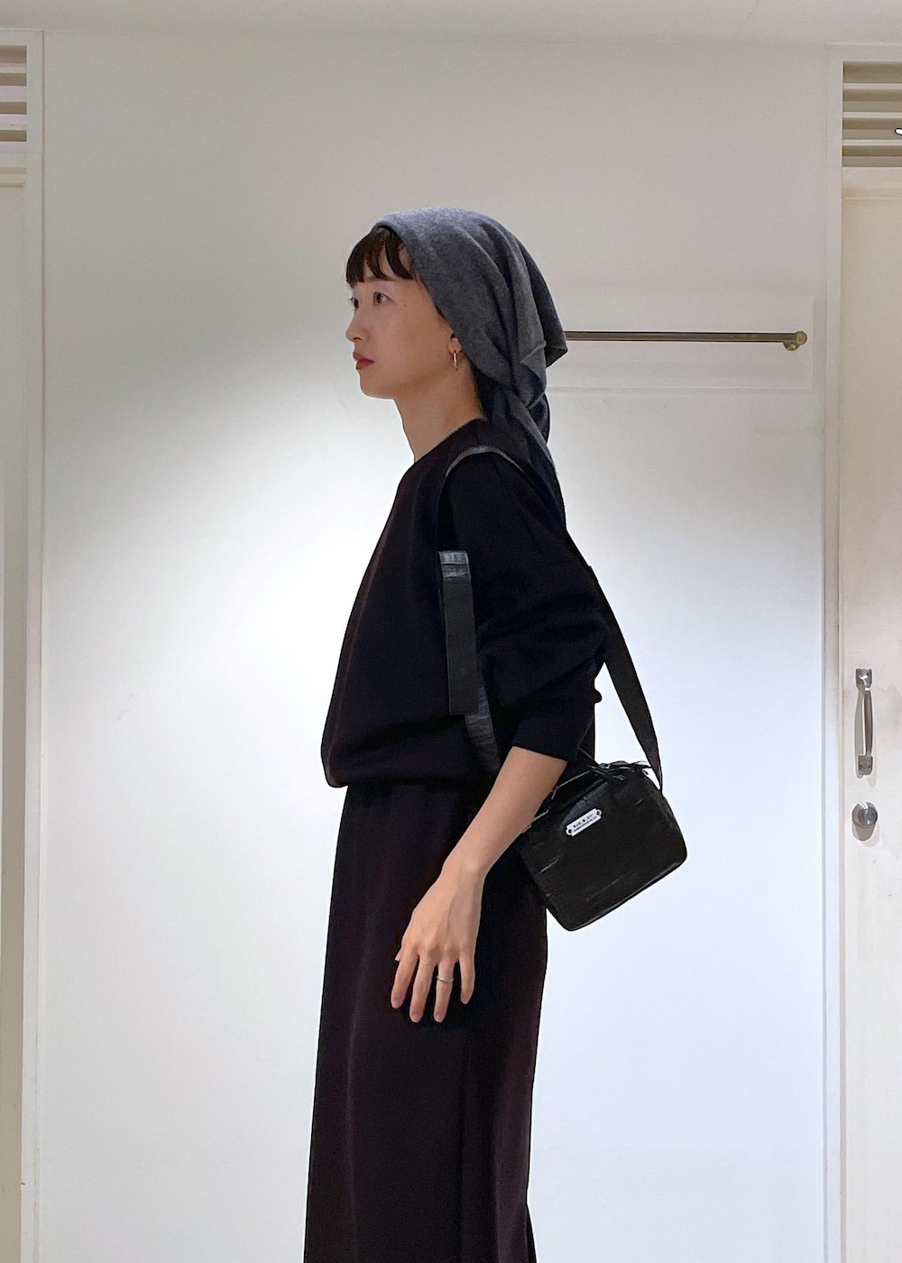 ブルー系のピーコート、ブラック系のブーツ、ブラック系のスカートを着用したレディースの秋コーディネートの7枚目の写真