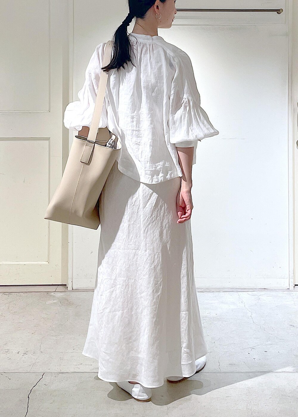 ホワイト系のその他シューズ、ホワイト系のシャツ/ブラウス、ベージュ系のトートバッグを着用したレディースの春コーディネートの7枚目の写真