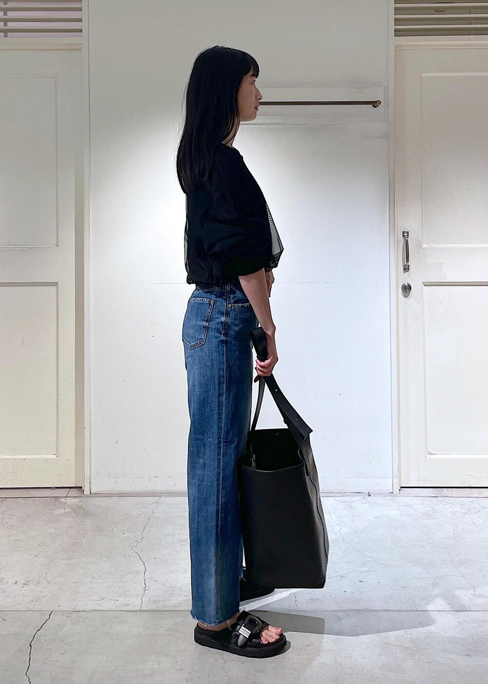 ブラック系のサンダル、ブラック系のトートバッグ、ブラック系のTシャツ/カットソーを着用したレディースの春コーディネートの2枚目の写真