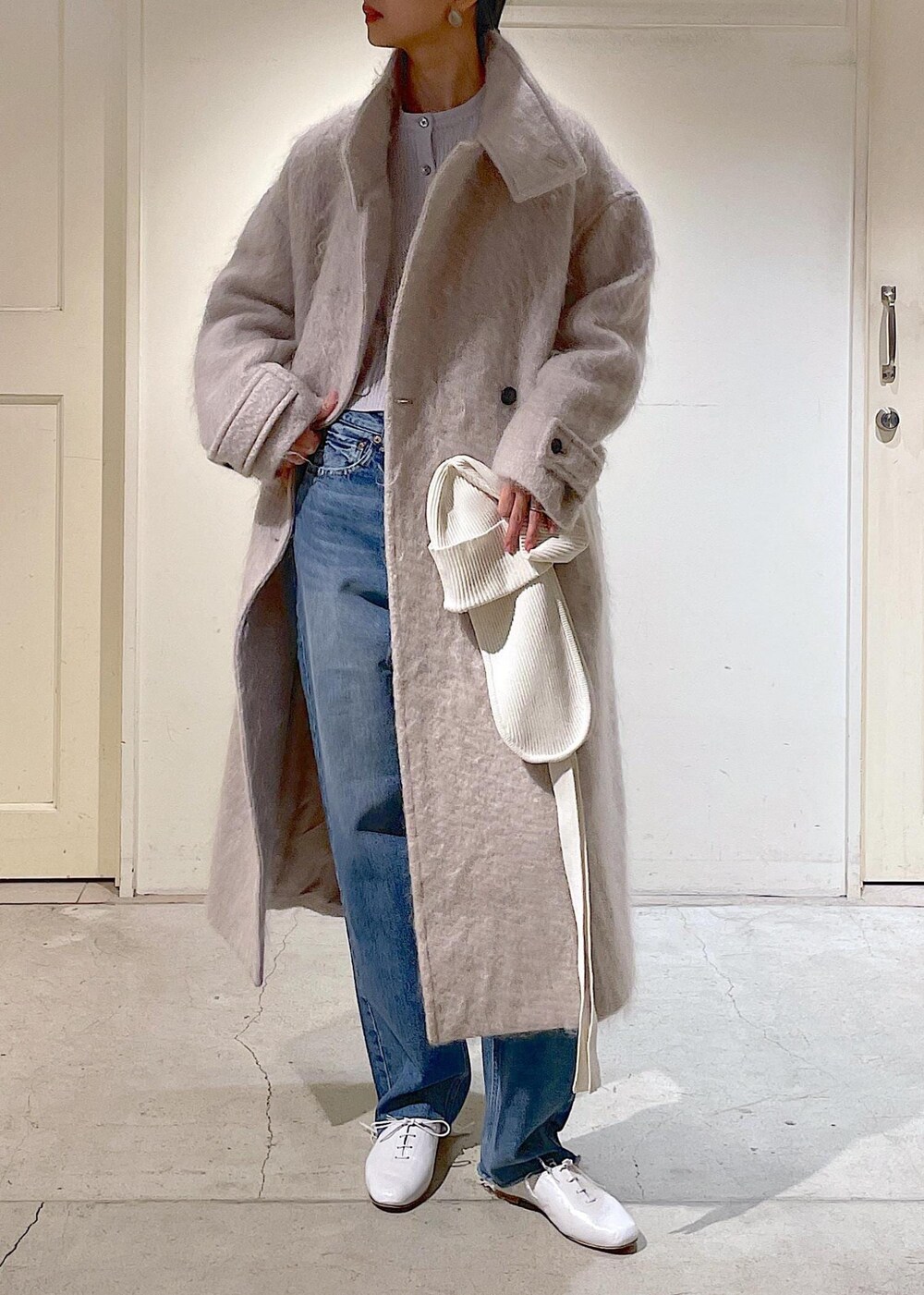 グレー系のその他アウター、ブルー系のデニムパンツ、ホワイト系のその他シューズを着用したレディースの冬コーディネートの2枚目の写真
