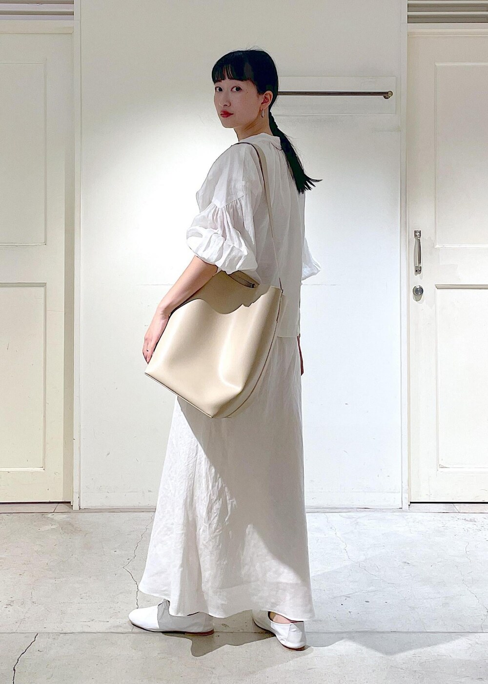 ホワイト系のその他シューズ、ホワイト系のシャツ/ブラウス、ベージュ系のトートバッグを着用したレディースの春コーディネートの6枚目の写真