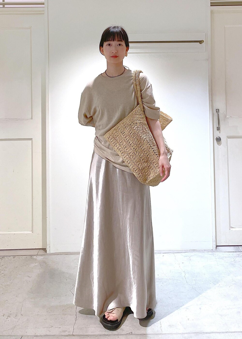 ベージュ系のサンダル、ベージュ系のスカート、ベージュ系のTシャツ/カットソーを着用したレディースの春コーディネートの3枚目の写真