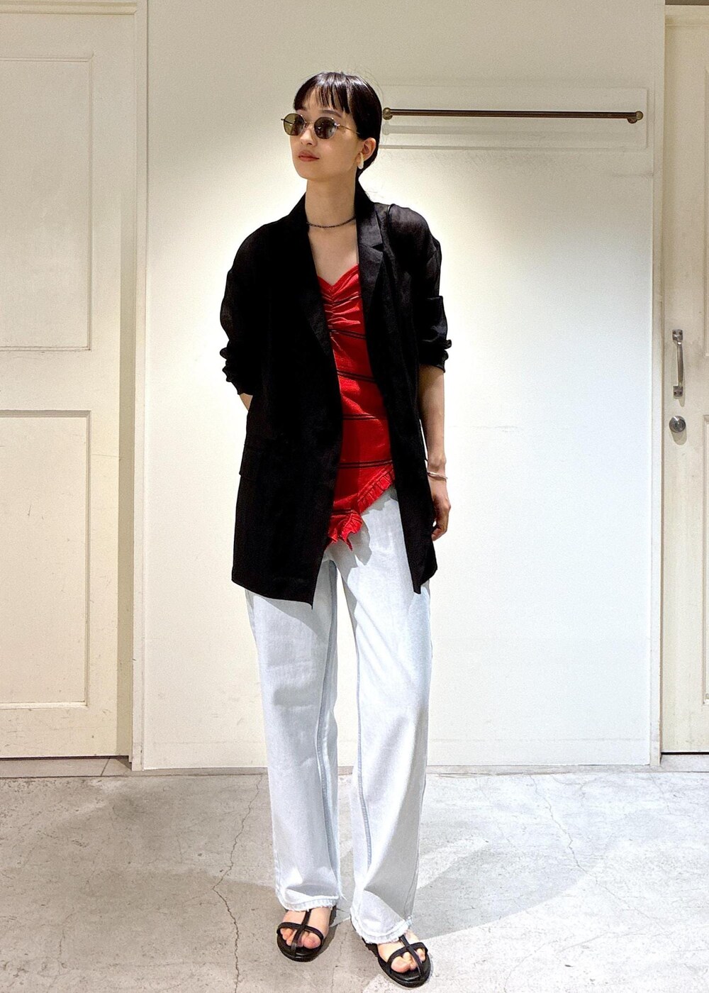 ブルー系のデニムパンツ、ブラック系のサンダル、グレー系のテーラードジャケットを着用したレディースの夏コーディネートの5枚目の写真