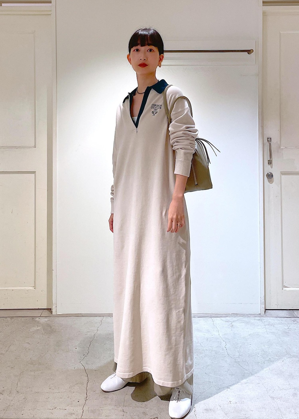 ホワイト系のその他シューズ、ベージュ系のスラックス、ホワイト系のチューブトップを着用したレディースの冬コーディネートの9枚目の写真