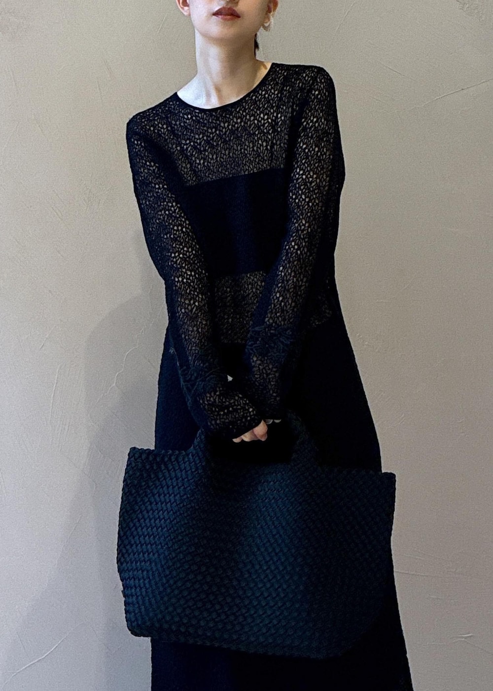 ブラック系のトートバッグ、ブラック系のワンピース、ホワイト系のスニーカーを着用したレディースの秋コーディネートの7枚目の写真