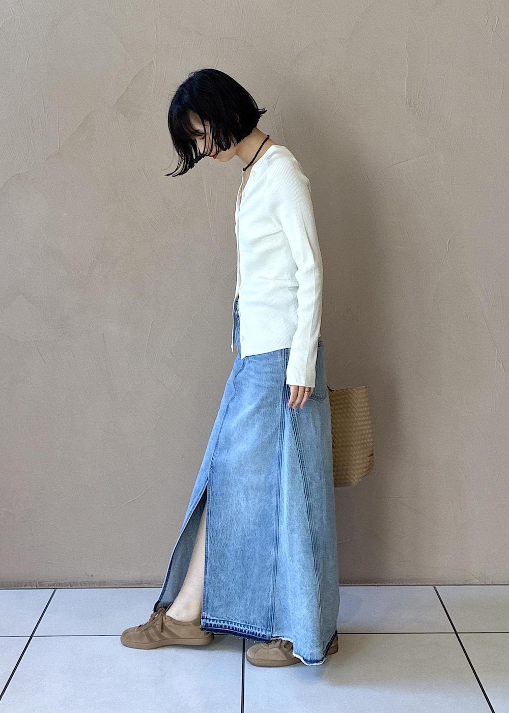 ホワイト系のカーディガン/ボレロ、イエロー系のスニーカー、ブルー系のデニムスカートを着用したレディースの春コーディネートの2枚目の写真