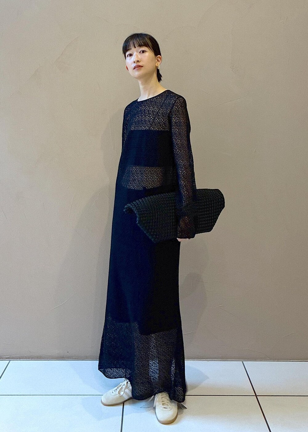 ブラック系のトートバッグ、ブラック系のワンピース、ホワイト系のスニーカーを着用したレディースの秋コーディネートの2枚目の写真