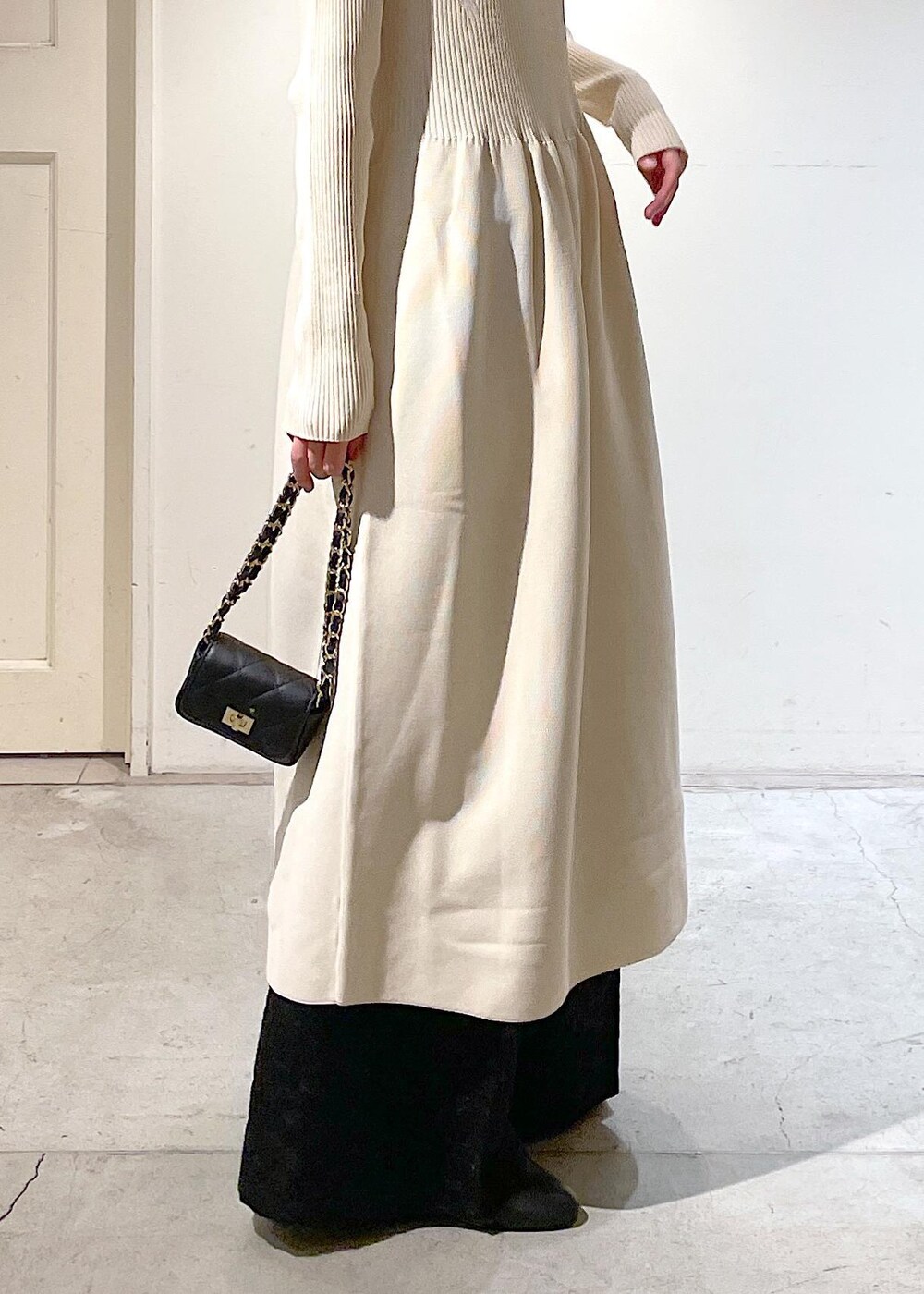 ブラック系のショルダーバッグ、ブラック系のブーツ、ブラック系のその他パンツを着用したレディースの冬コーディネートの6枚目の写真