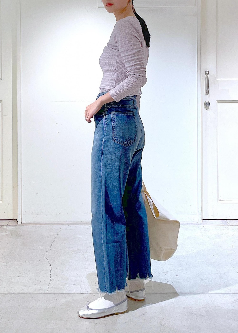 シルバー系のバレエシューズ、ブルー系のデニムパンツ、ピンク系のチューブトップを着用したレディースの春コーディネートの2枚目の写真