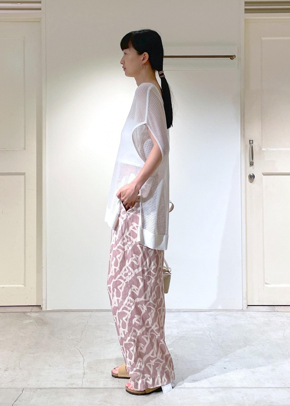 イエロー系のその他パンツ、ホワイト系のチューブトップ、ベージュ系のショルダーバッグを着用したレディースの夏コーディネートの2枚目の写真