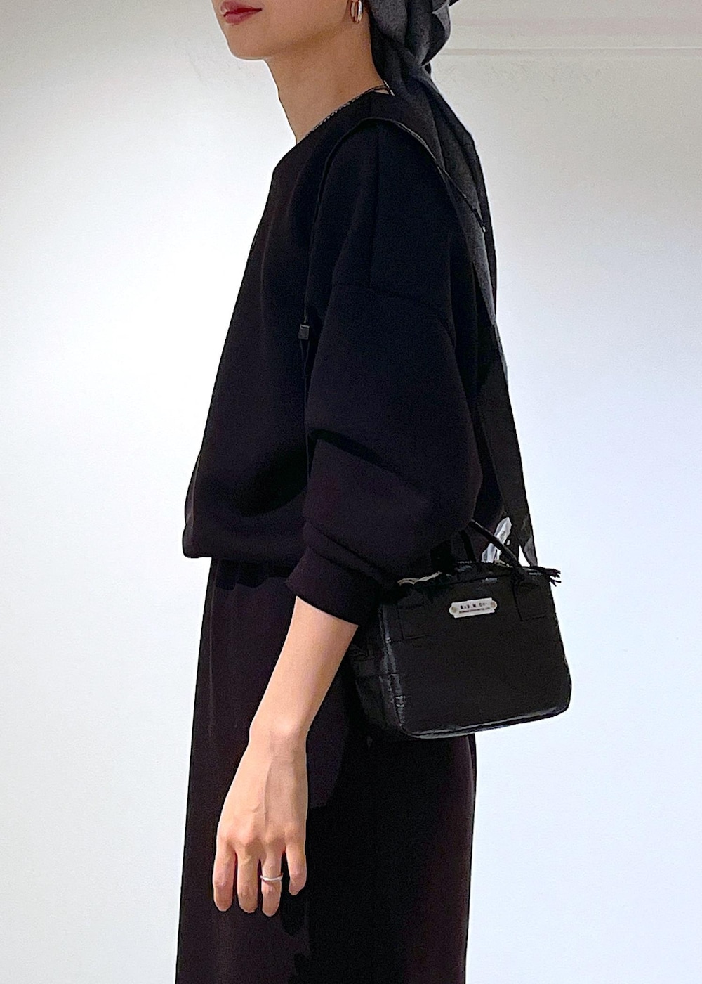 ブルー系のピーコート、ブラック系のブーツ、ブラック系のスカートを着用したレディースの秋コーディネートの10枚目の写真