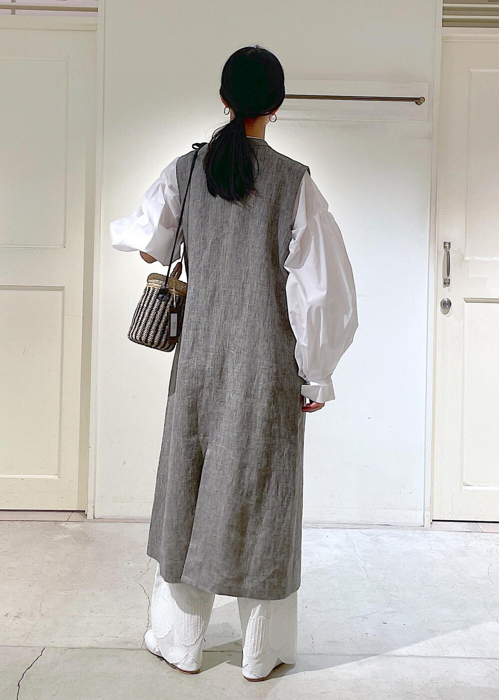 ホワイト系のシャツ/ブラウス、ホワイト系のその他シューズ、ブラック系のジャンパースカートを着用したレディースの冬コーディネートの6枚目の写真