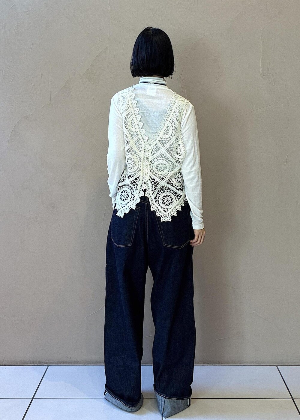 ホワイト系のその他アウター、ホワイト系のチェスターコート、ブラック系のハンドバッグを着用したレディースの秋コーディネートの9枚目の写真