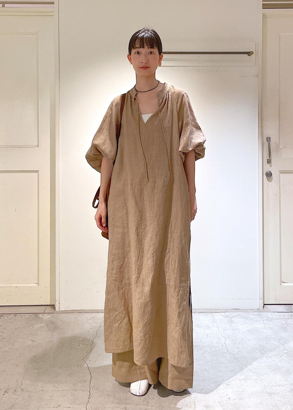 ホワイト系のチューブトップ、ベージュ系のその他パンツ、ベージュ系のワンピースを着用したレディースの春コーディネートの6枚目の写真