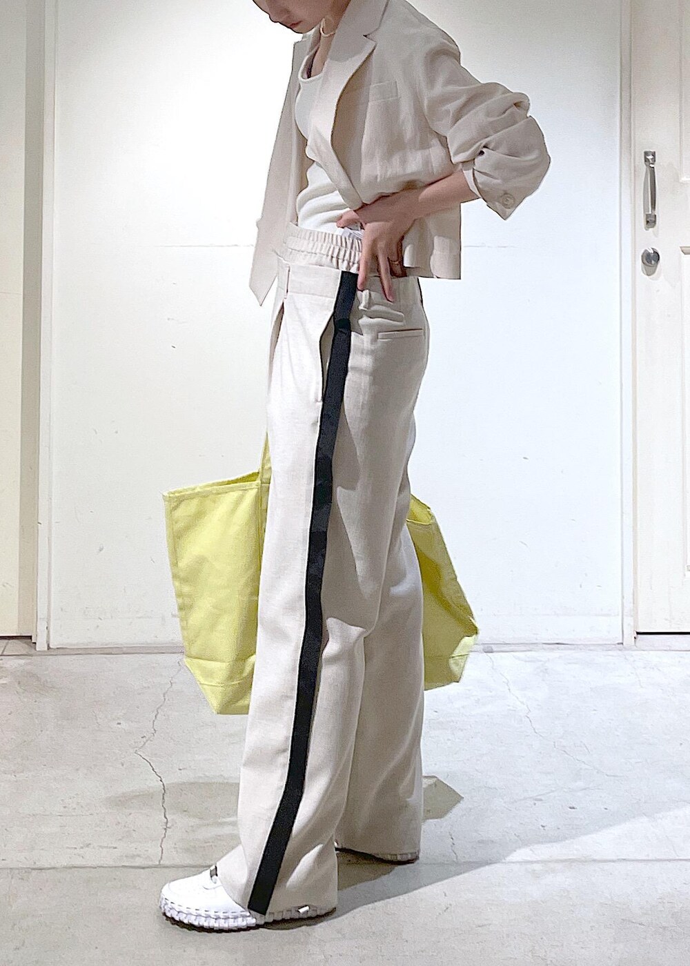 ホワイト系のキャミソール、ホワイト系のテーラードジャケットを着用したレディースの春コーディネートの6枚目の写真