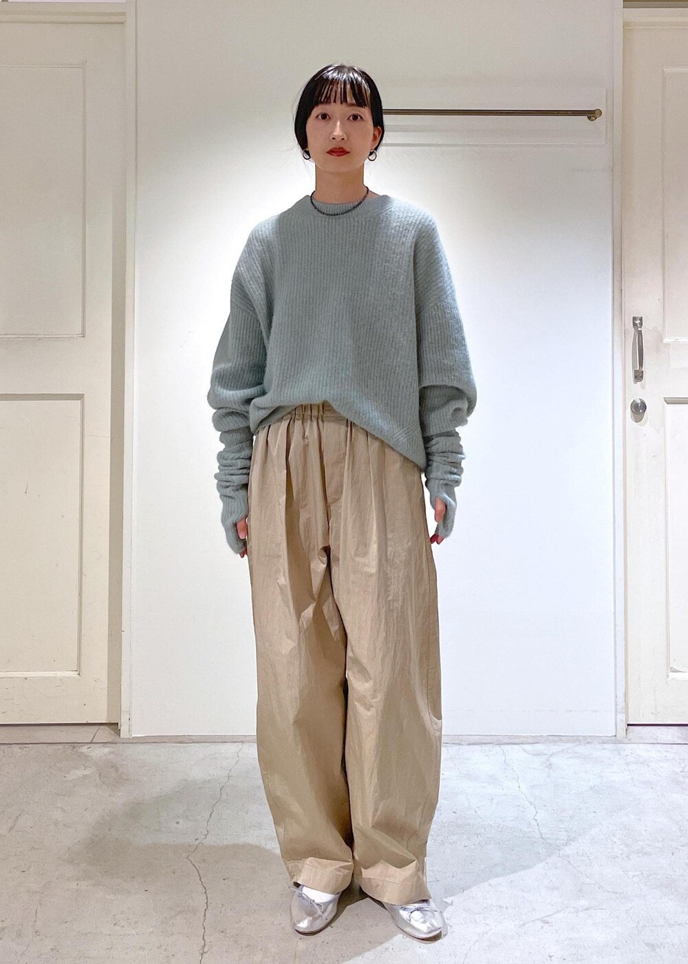 シルバー系のバレエシューズ、グレー系のショルダーバッグ、グリーン系のニット/セーターを着用したレディースの秋コーディネートの4枚目の写真