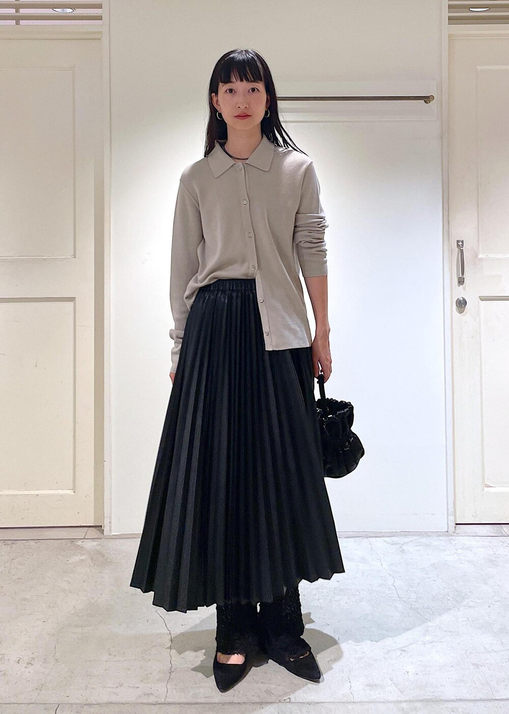 グレー系のカーディガン/ボレロ、ブラック系のスカート、ブラック系のショルダーバッグを着用したレディースの秋コーディネートの5枚目の写真