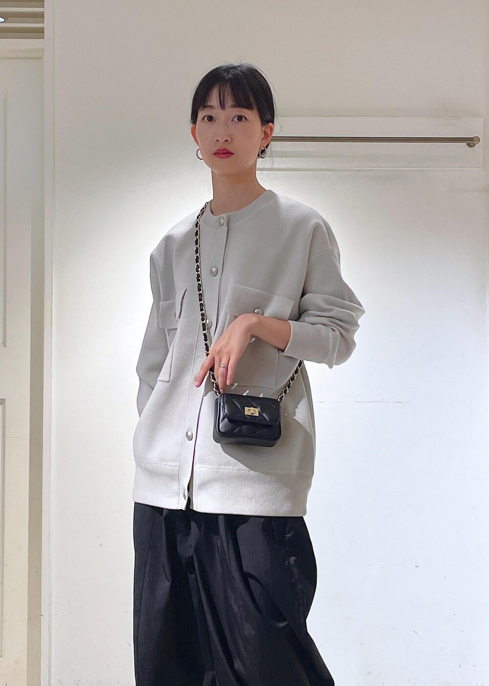 ブラック系のショルダーバッグ、ブラック系のカーゴパンツ、ブラック系のブーツを着用したレディースの秋コーディネートの3枚目の写真