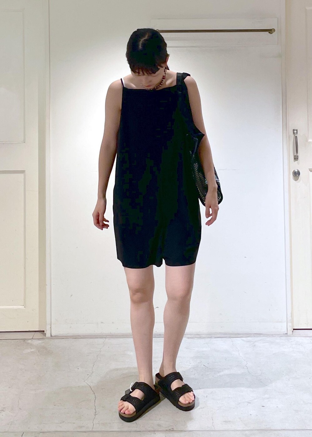 ブラック系のサンダル、ブラック系のトートバッグ、ブラック系のラッシュガードを着用したレディースの夏コーディネートの4枚目の写真