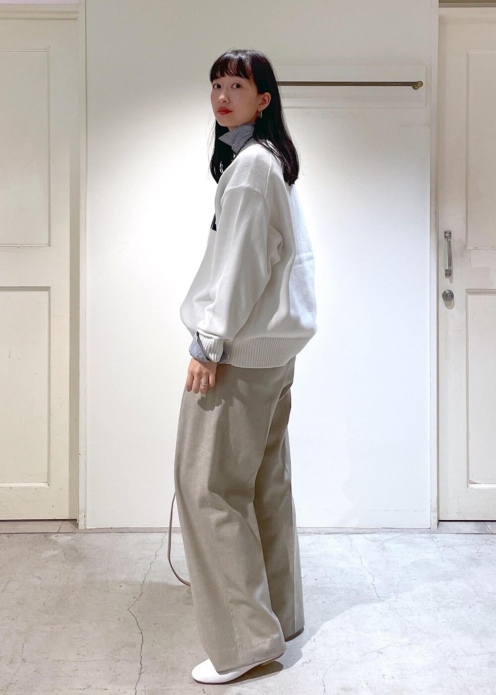 ホワイト系のその他シューズ、ブルー系のシャツ/ブラウス、ベージュ系のスラックスを着用したレディースの冬コーディネートの2枚目の写真