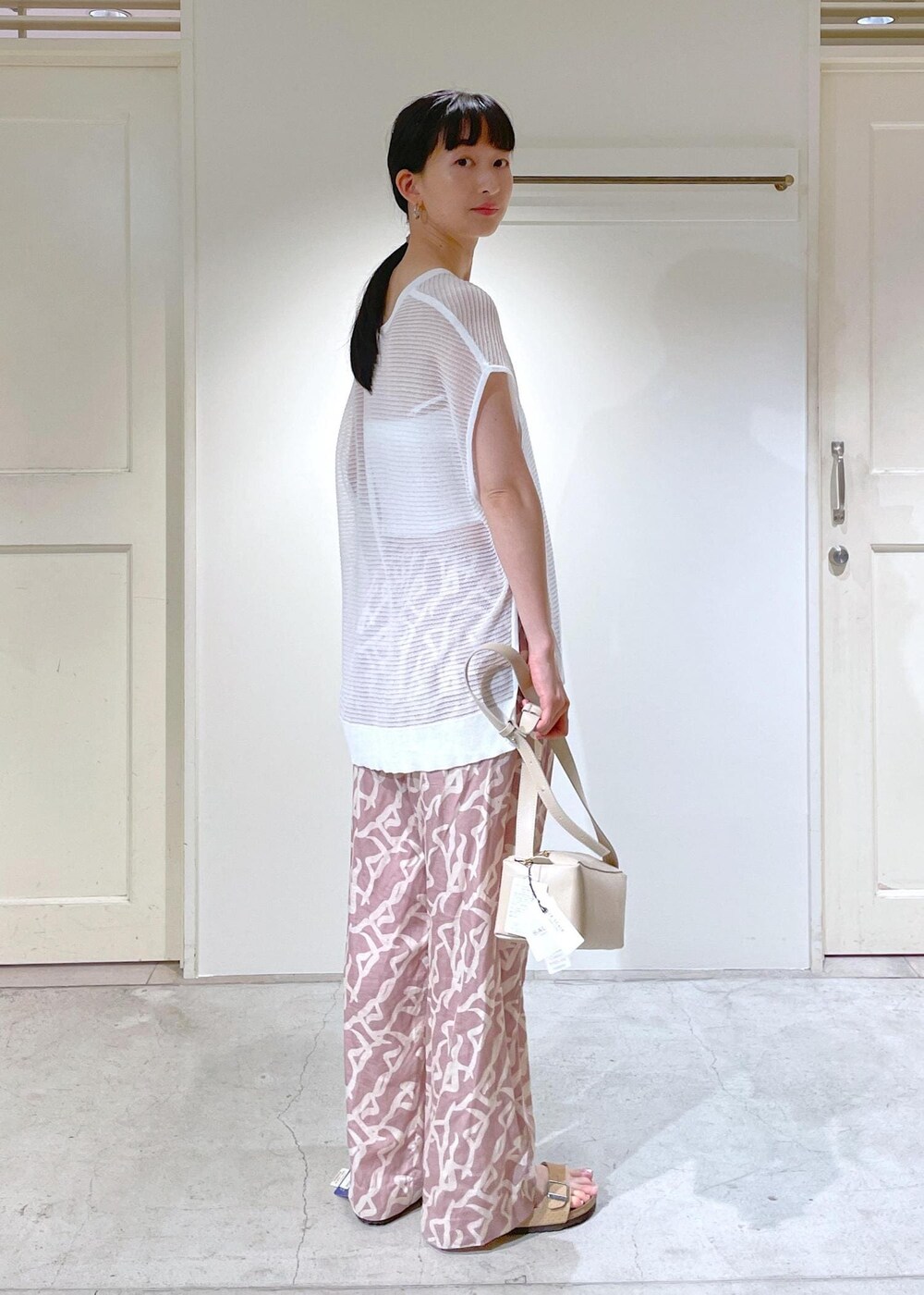 イエロー系のその他パンツ、ホワイト系のチューブトップ、ベージュ系のショルダーバッグを着用したレディースの夏コーディネートの4枚目の写真