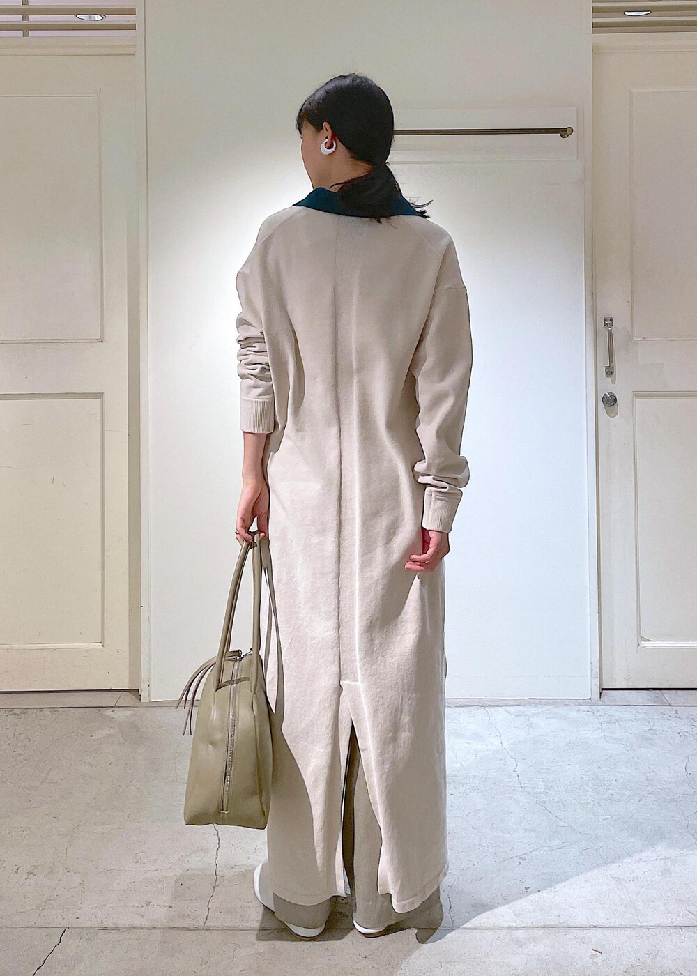 ホワイト系のその他シューズ、ベージュ系のスラックス、ホワイト系のチューブトップを着用したレディースの冬コーディネートの8枚目の写真