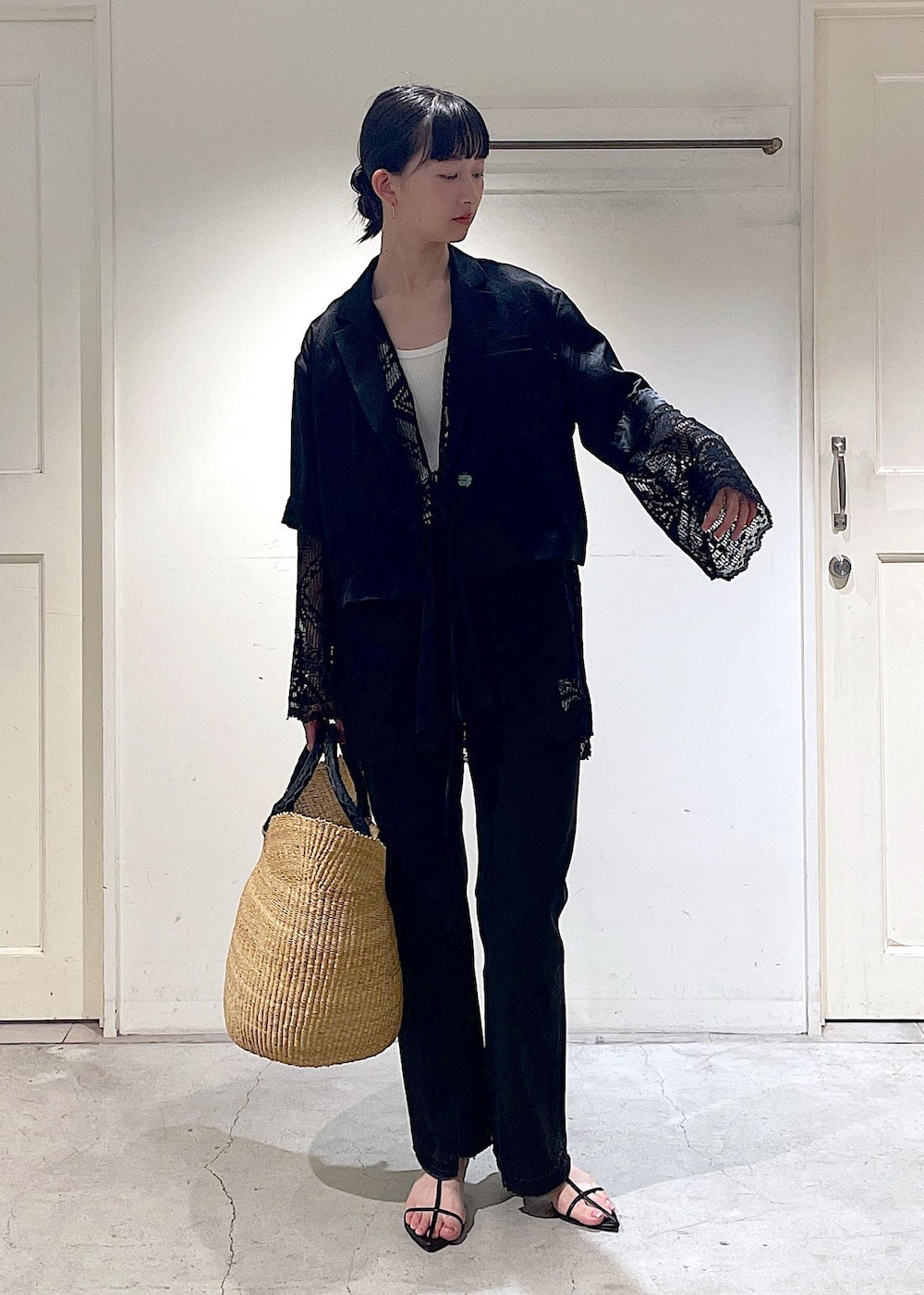 グレー系のデニムパンツ、ブラック系のノーカラージャケット、ブラック系のサンダルを着用したレディースの夏コーディネートの2枚目の写真