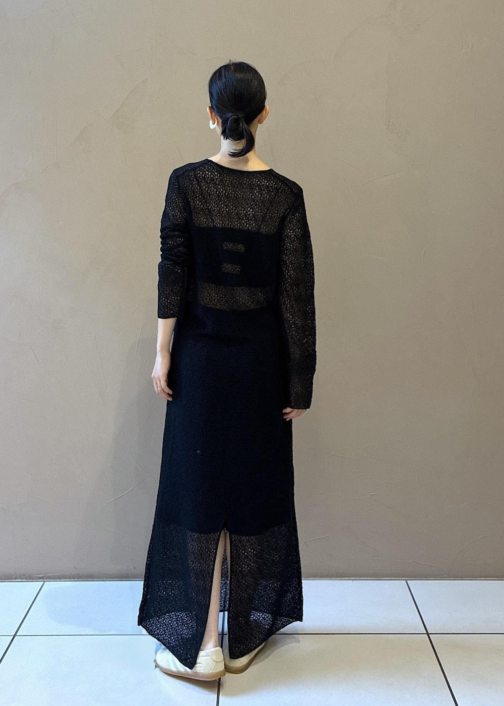 ブラック系のトートバッグ、ブラック系のワンピース、ホワイト系のスニーカーを着用したレディースの秋コーディネートの5枚目の写真