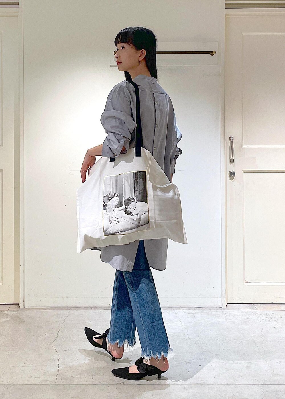 ブルー系のデニムパンツ、グレー系のシャツ/ブラウス、ホワイト系のトートバッグを着用したレディースの夏コーディネートの5枚目の写真