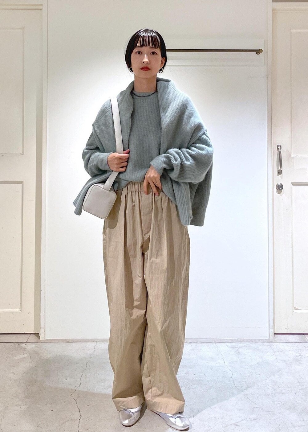 シルバー系のバレエシューズ、グレー系のショルダーバッグ、グリーン系のニット/セーターを着用したレディースの秋コーディネートの7枚目の写真