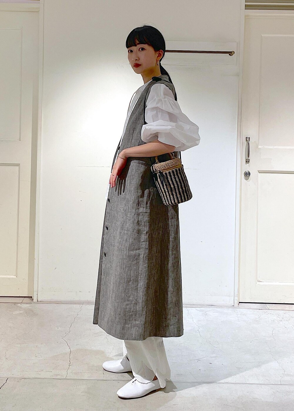 ホワイト系のシャツ/ブラウス、ホワイト系のその他シューズ、ブラック系のジャンパースカートを着用したレディースの冬コーディネートの2枚目の写真