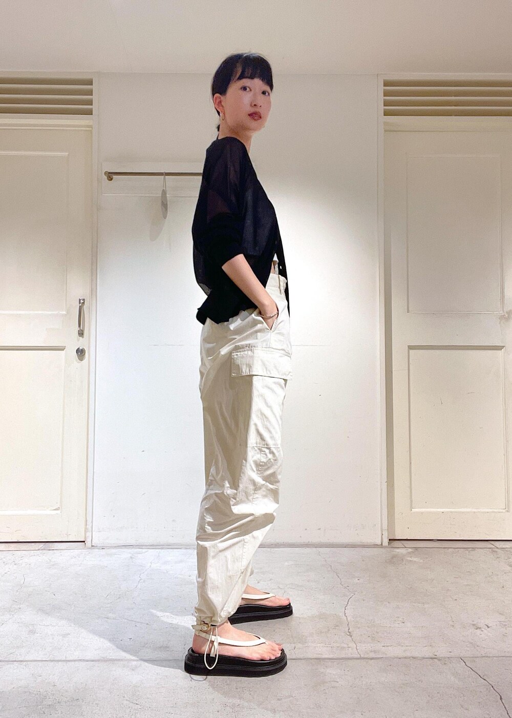 ブラック系のカーディガン/ボレロ、ホワイト系のカーゴパンツ、ホワイト系のサンダルを着用したレディースの夏コーディネートの3枚目の写真