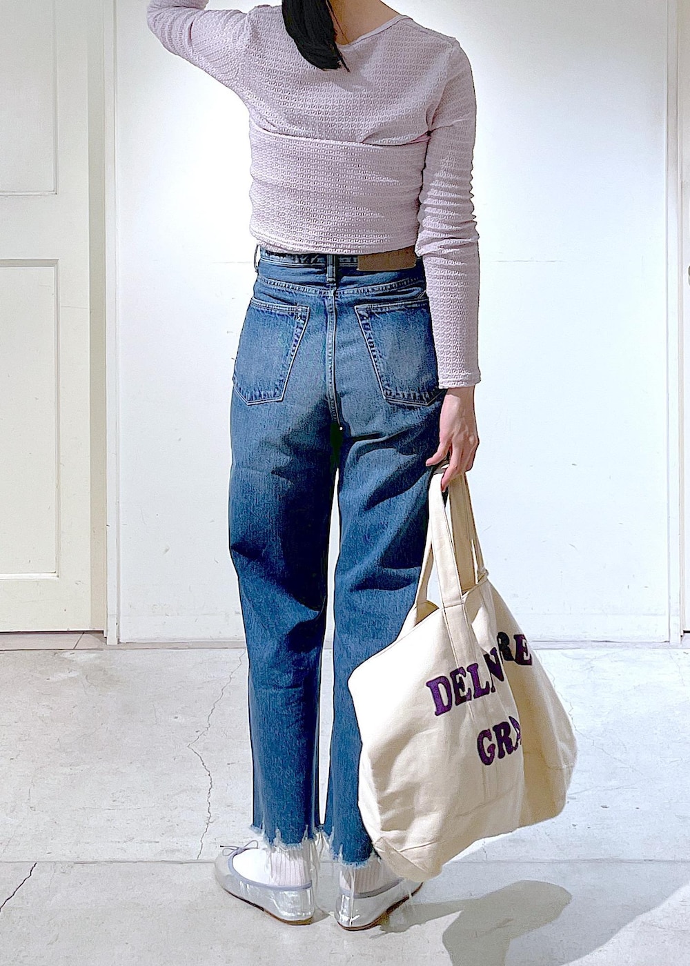 シルバー系のバレエシューズ、ブルー系のデニムパンツ、ピンク系のチューブトップを着用したレディースの春コーディネートの4枚目の写真