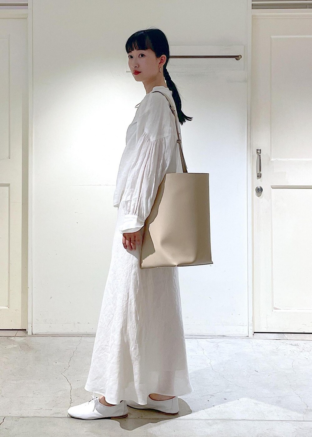 ホワイト系のその他シューズ、ホワイト系のシャツ/ブラウス、ベージュ系のトートバッグを着用したレディースの春コーディネートの5枚目の写真
