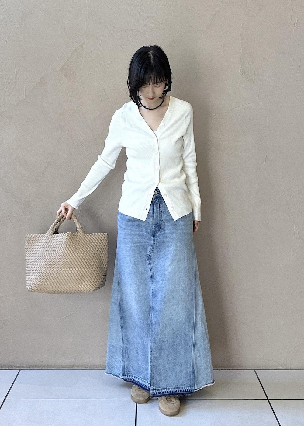 ホワイト系のカーディガン/ボレロ、イエロー系のスニーカー、ブルー系のデニムスカートを着用したレディースの春コーディネートの3枚目の写真