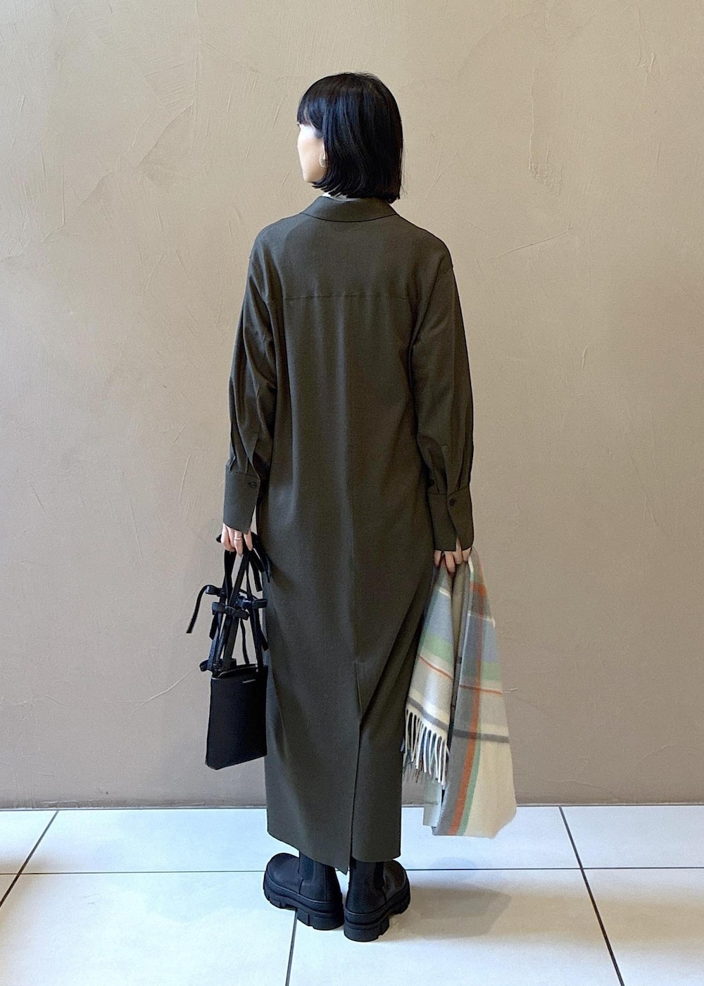 ブラック系のブーツ、グリーン系のワンピース、ホワイト系のニット/セーターを着用したレディースの冬コーディネートの6枚目の写真