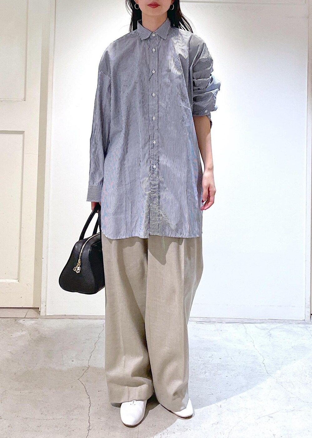 ホワイト系のその他シューズ、ブルー系のシャツ/ブラウス、ベージュ系のスラックスを着用したレディースの冬コーディネートの6枚目の写真