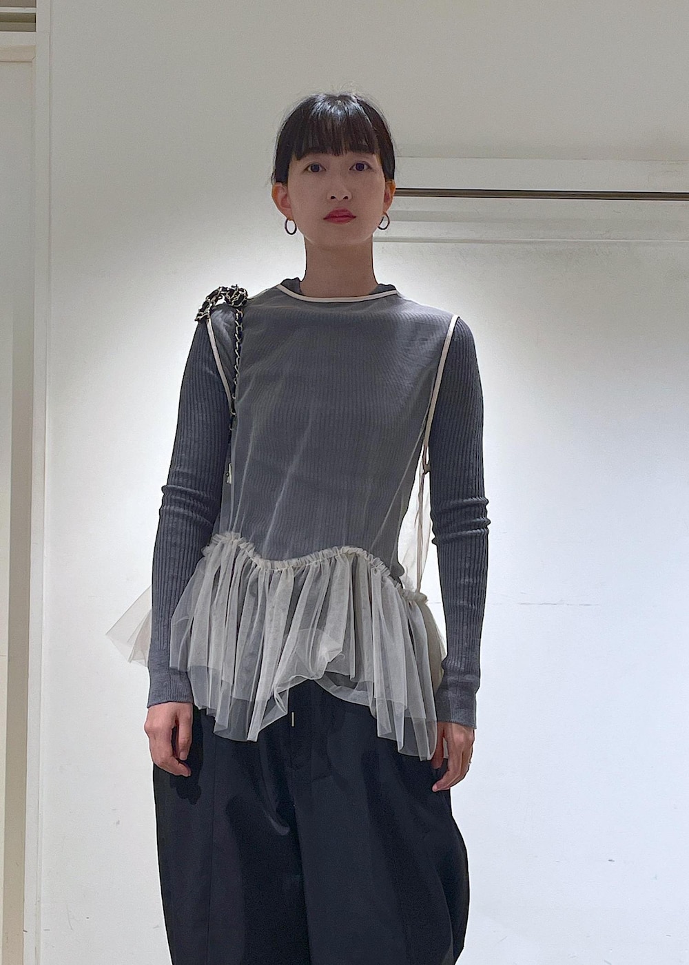 ブラック系のショルダーバッグ、ブラック系のカーゴパンツ、ホワイト系のベストを着用したレディースの秋コーディネートの7枚目の写真