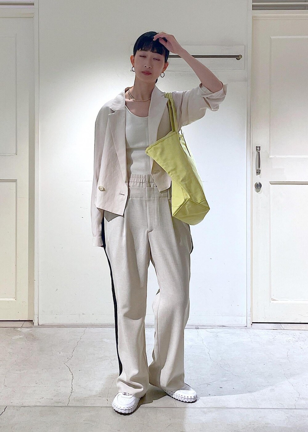 ホワイト系のキャミソール、ホワイト系のテーラードジャケットを着用したレディースの春コーディネートの2枚目の写真