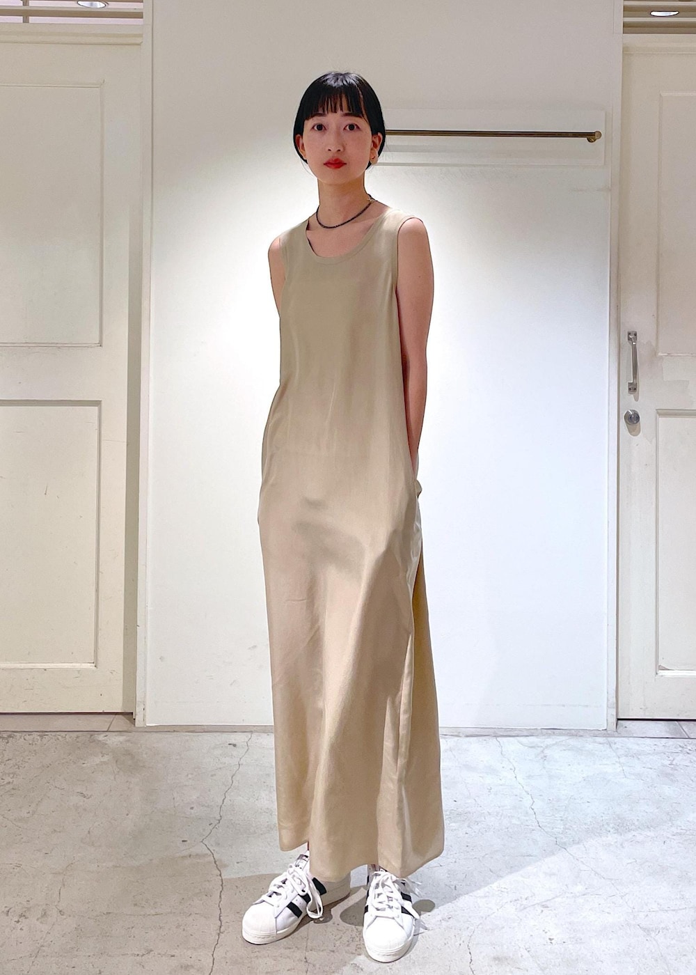 ベージュ系のワンピース、ホワイト系のブルゾン、ホワイト系のスニーカーを着用したレディースの冬コーディネートの8枚目の写真