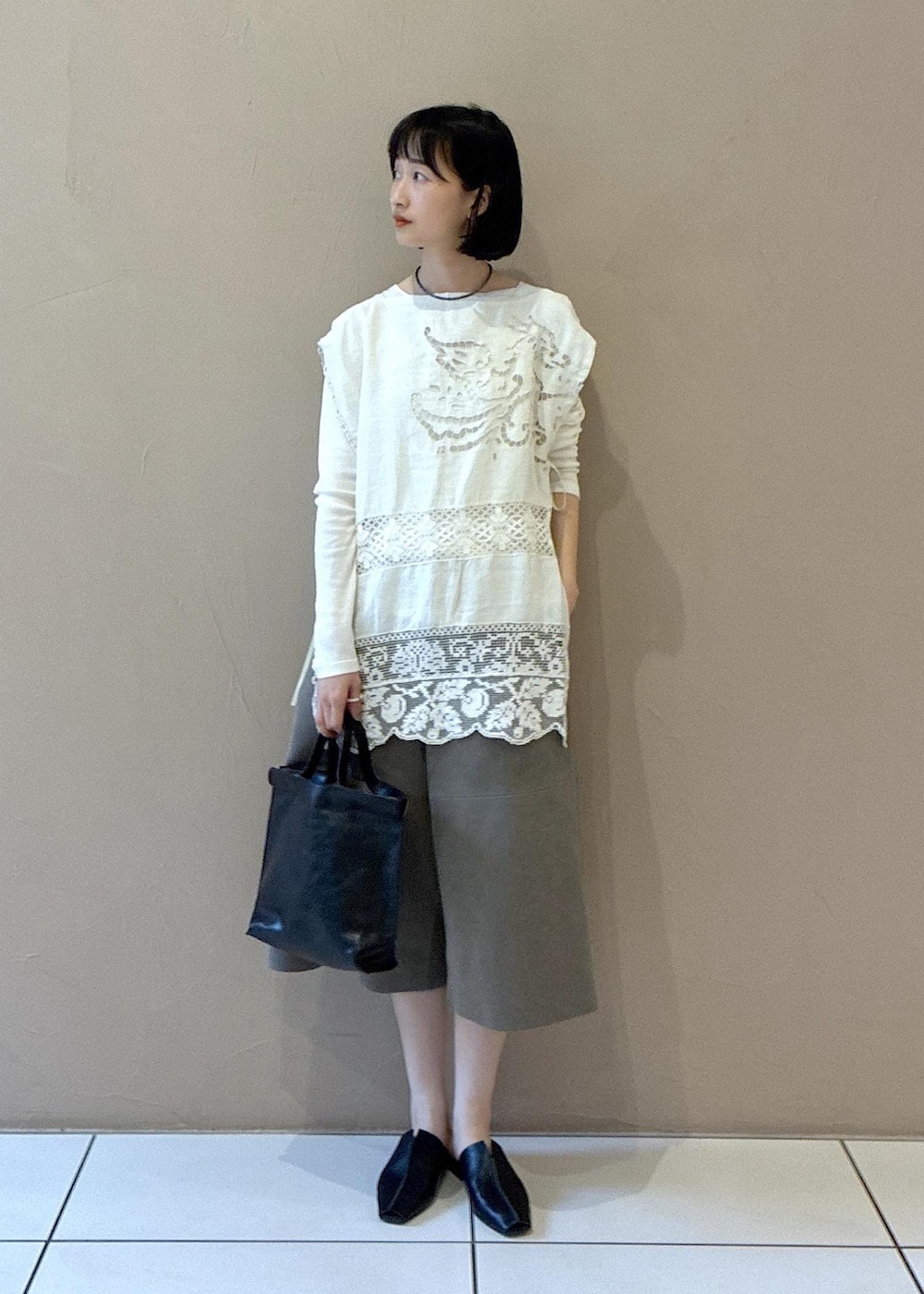 ホワイト系のTシャツ/カットソー、ブラック系のその他シューズ、ベージュ系のその他パンツを着用したレディースの春コーディネートの2枚目の写真