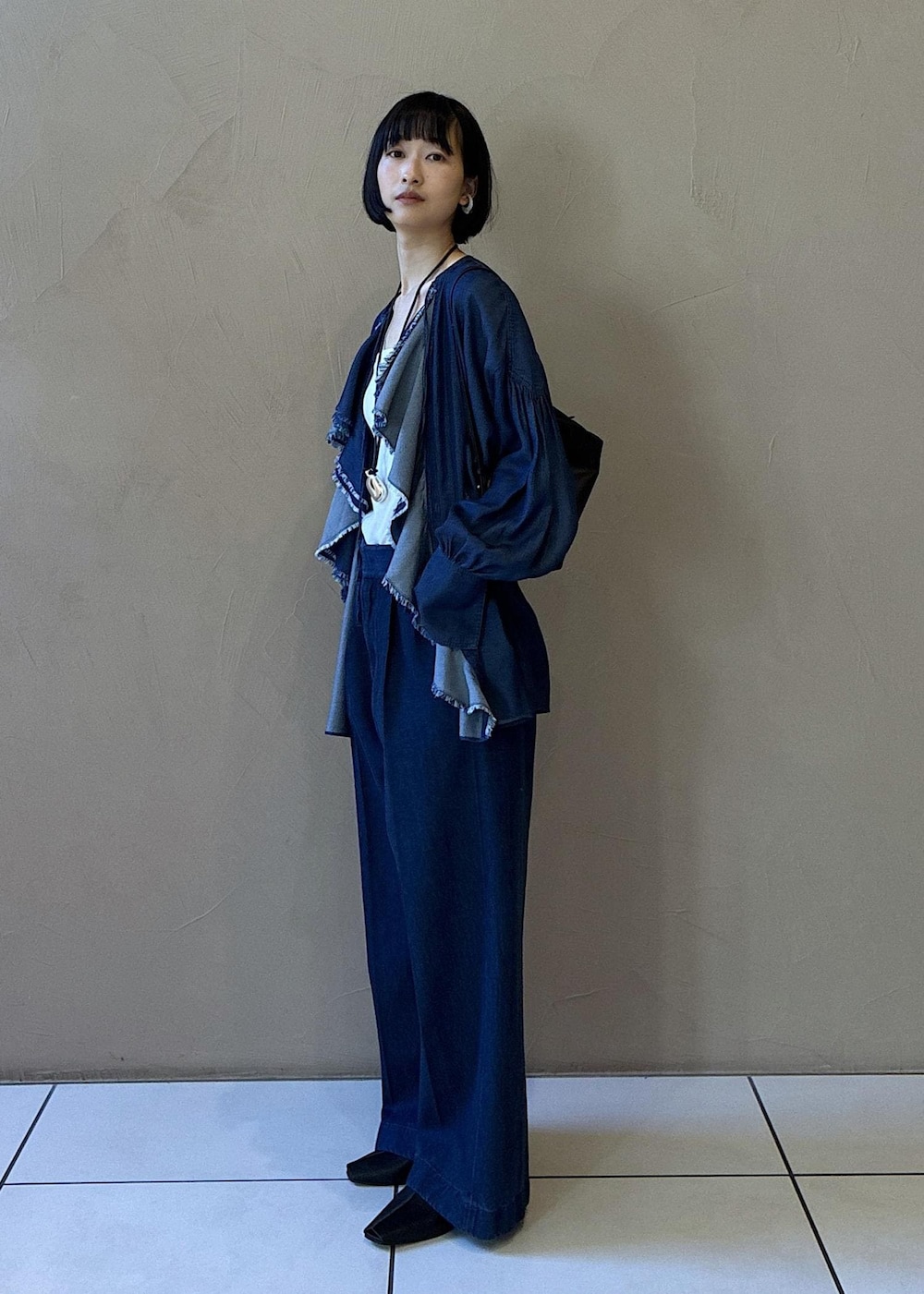 ブラック系のその他シューズ、ブルー系のシャツ/ブラウス、ブルー系のデニムパンツを着用したレディースの冬コーディネートの2枚目の写真